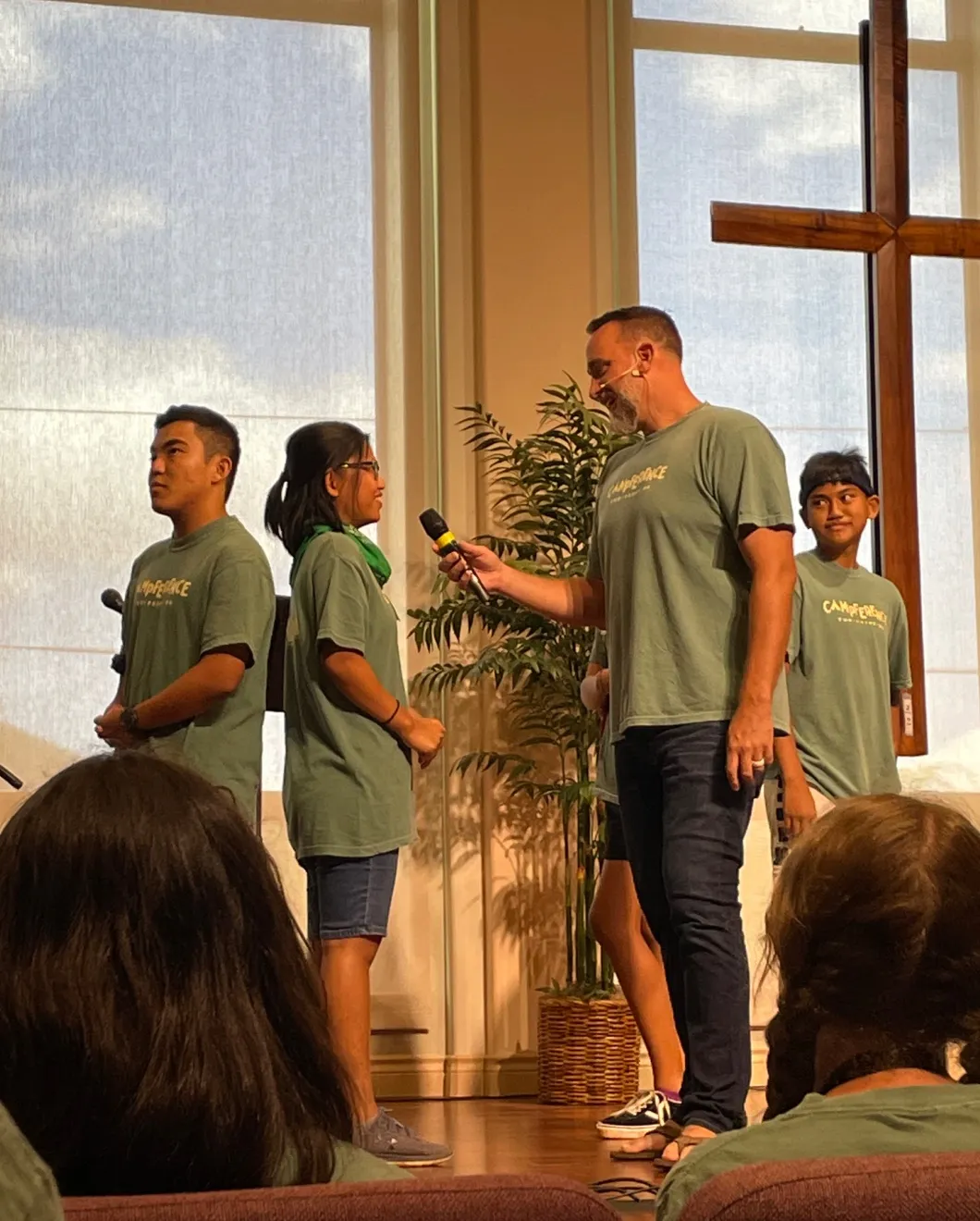 Youth leaders sharing in front of the sanctuary cross